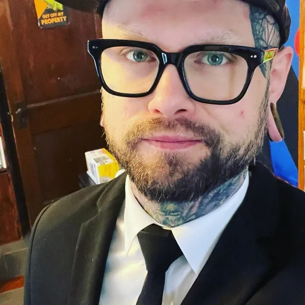 Axl Ibiza, wearing black glasses and a suit.